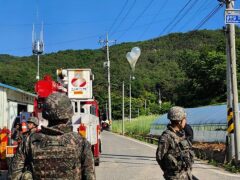 Balloons filled with rubbish hang on electric wires as South Korean army soldiers stand guard in Muju (Jeonbuk Fire Headquarters via AP, File)