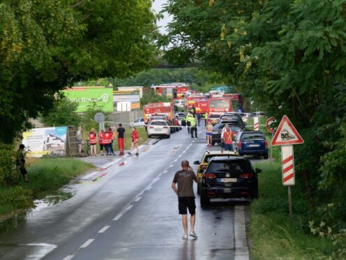 Firefighters’ vehicles and emergency vehicles on the site of the collision of a bus with a train near the town of Nove Zamky, Slovakia (Henrich Misovic/TASR via AP)