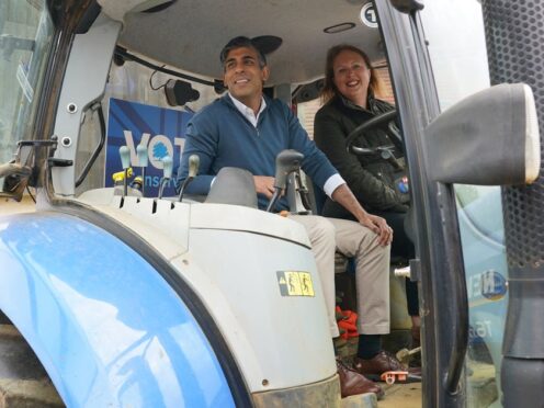 Prime Minister Rishi Sunak and Attorney General and parliamentary candidate for Banbury Victoria Prentis sit in a tractor during a visit to Wykham Park Farm (Jonathan Brady/PA)