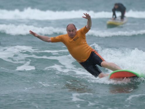 Liberal Democrat leader Sir Ed Davey falls from a surfboard during a visit to Big Blue Surf School in Bude, Cornwall (Matt Keeble/PA)