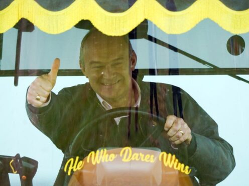Sir Ed Davey drives a tractor during a visit to Owl Lodge in Lacock, Wiltshire (Andrew Matthews/PA)