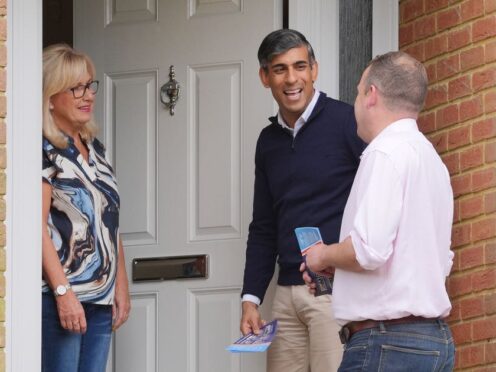 Prime Minister Rishi Sunak with local parliamentary candidate Paul Holmes (right) speaking to a voter during a canvassing session (Jonathan Brady/PA)