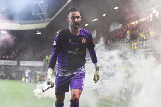 Dundee United's Mark Birighitti throws away a flare