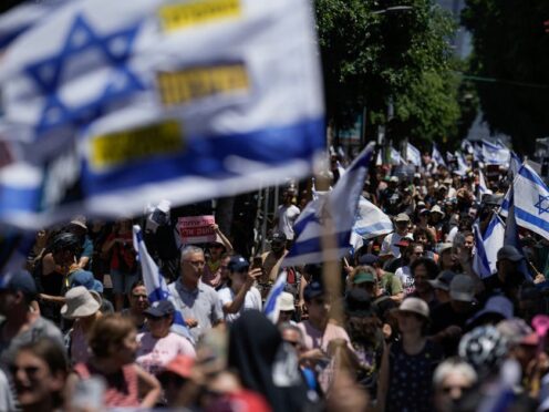 Demonstrators march with Israeli flags during a protest marking nine months since the start of the war and calling for the release of hostages held in the Gaza Strip by the Hamas militant group, in Tel Aviv, Israel (Leo Correa/AP)