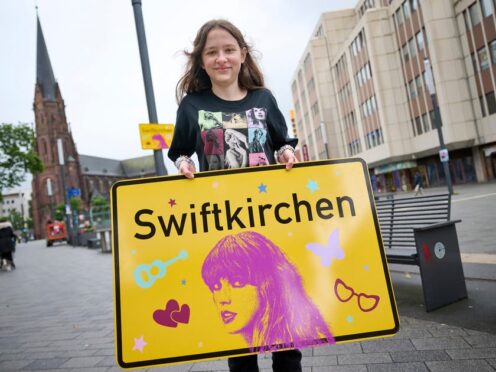 Schoolgirl Aleshanee Westhoff shows a ‘Swiftkirchen’ sign in honour of musician Taylor Swift in Gelsenkirchen, Germany (Bernd Thissen/dpa via AP)