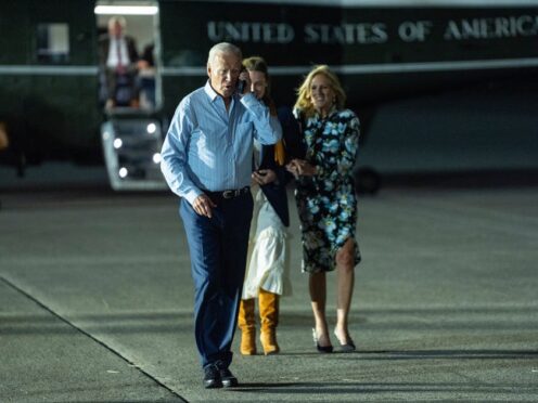 President Joe Biden, left, talks on the phone as he walks to board Air Force One (Evan Vucci/AP)