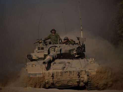 Israeli soldiers move on the top of a tank near the Israeli-Gaza border, as seen from southern Israel on Monday (AP Photo/Leo Correa)