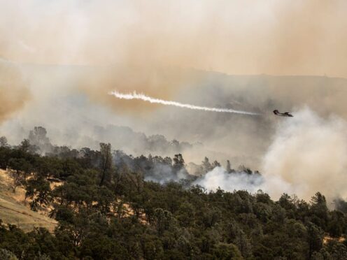 A Cal Fire OV-10 air tactical aircraft releases a puff of smoke while guiding a fire retardant drop during the Thompson Fire, in Oroville, California (Stephen Lam/San Francisco Chronicle/AP)