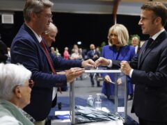 French President Emmanuel Macron, right, votes for the second round of the legislative elections in Le Touquet-Paris-Plage (Mohammed Badra/AP)