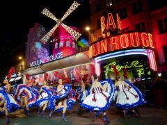 Dancers perform in front of the Moulin Rouge cabaret during the inauguration of the theatre’s windmill, in Paris (Thibault Camus/AP)