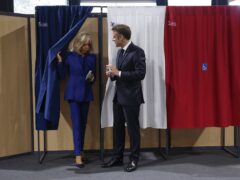 French President Emmanuel Macron and his wife Brigitte Macron leave the voting booth before voting for the second round of the legislative elections in Le Touquet-Paris-Plage, northern France (Mohammed Badra, Pool via AP)