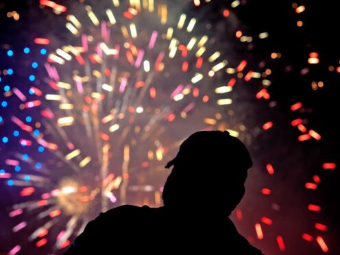 A fan watches a July 4 fireworks display after a baseball game between the Kansas City Royals and the Tampa Bay Rays (Charlie Riedel/AP)