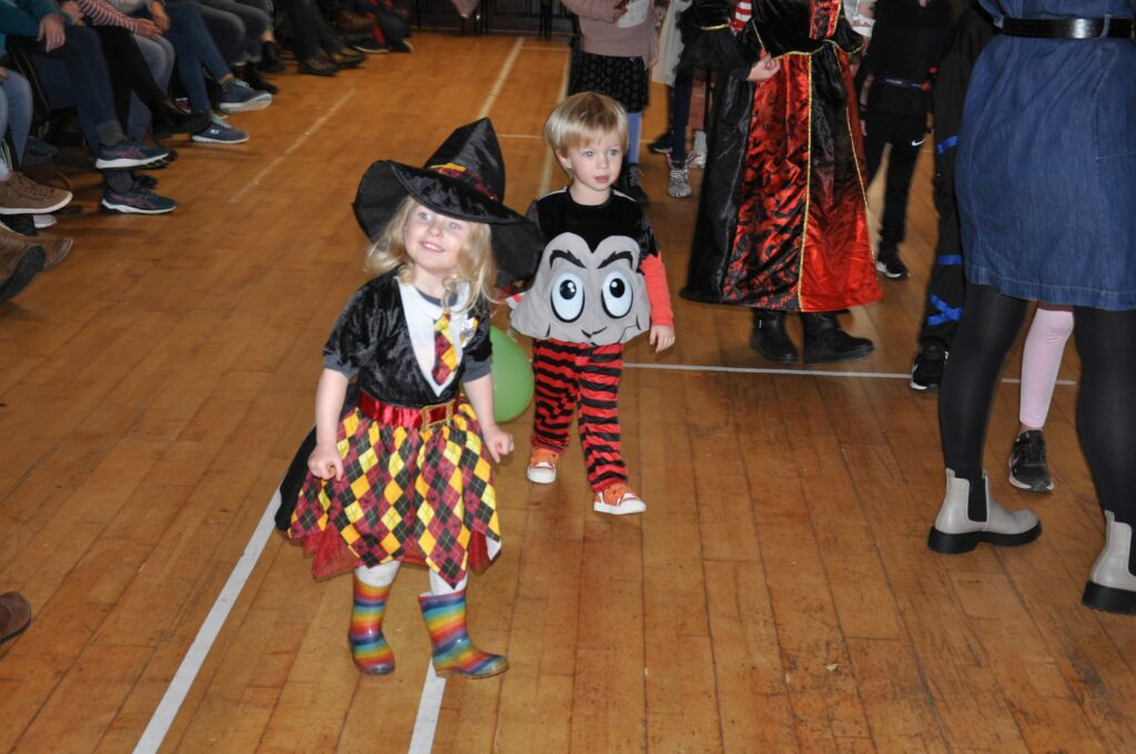 A little witch and pumpkin make their way around Shiskine Hall.
