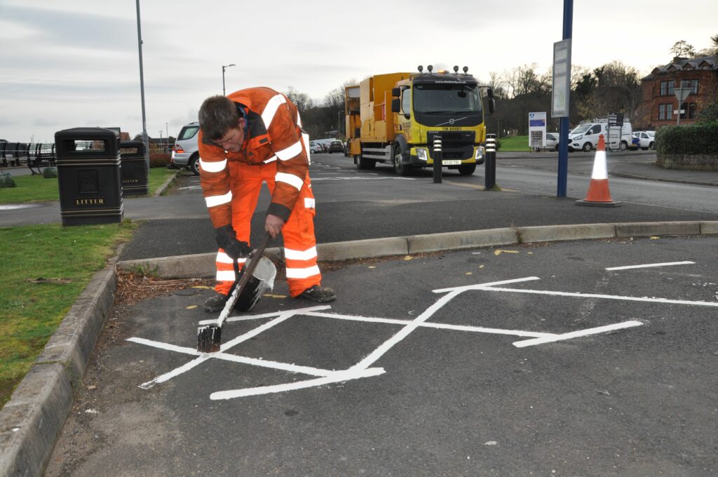 A Council contractor paints parking lines on the Brodick shorefront.