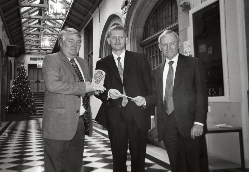 Brian Taylor, political editor of the BBC and George Reid, deputy presiding officer, present Craig Borland of Whiting Bay with his Kenny McIntyre Award for Scottish Journalism in the black and white corridor of the Scottish Parliament.