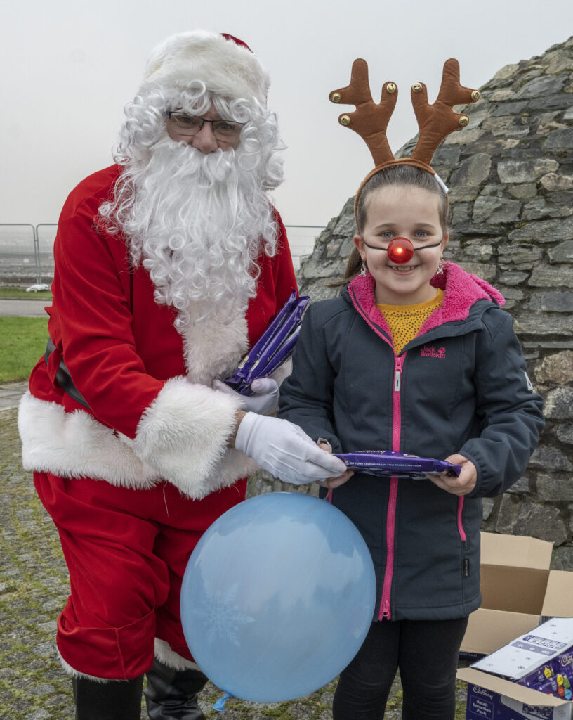 Reindeer impersonator Estelle Gibb receives a present from Santa at Caol Shopping Square. Photograph: Iain Ferguson, alba.photos

NO F52 SANTA IN CAOL 02