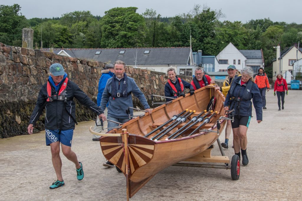 June – Spirits ran high at the maiden voyage of Moonshine, the latest skiff built by Rory Cowan for the Arran Coastal Rowing Club.