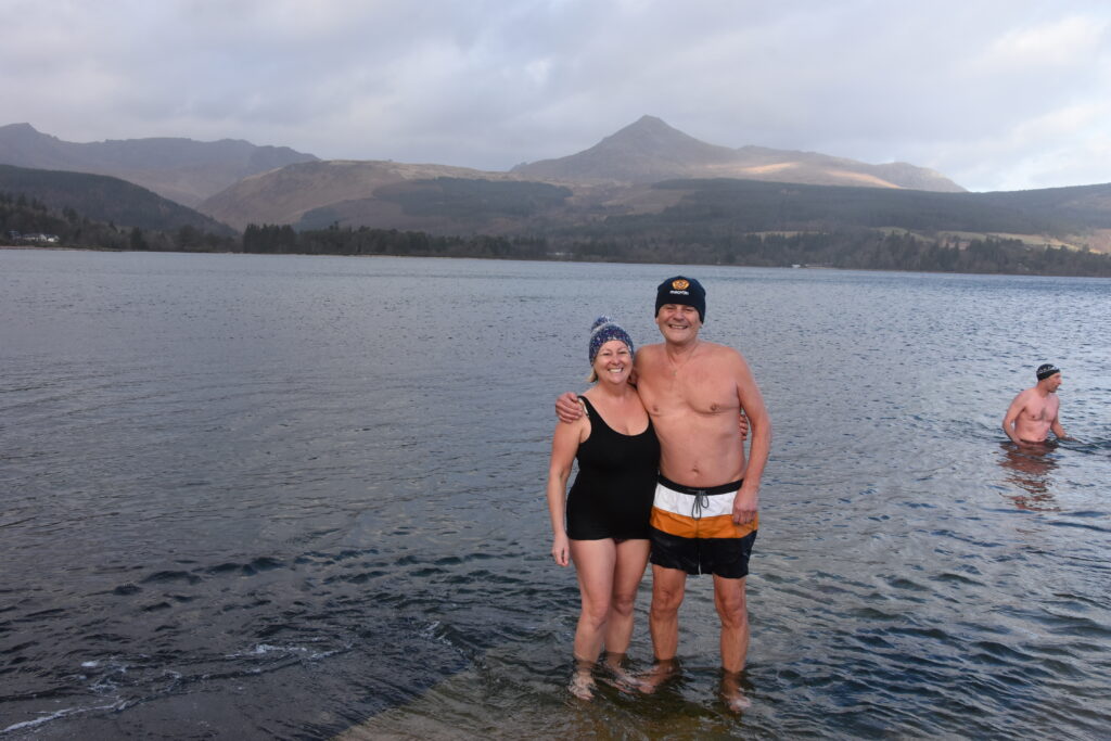 Two dookers smile for the camera with Goatfell behind them.