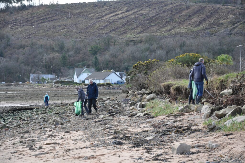 Litter pickers search among the rocks towards Cordon.