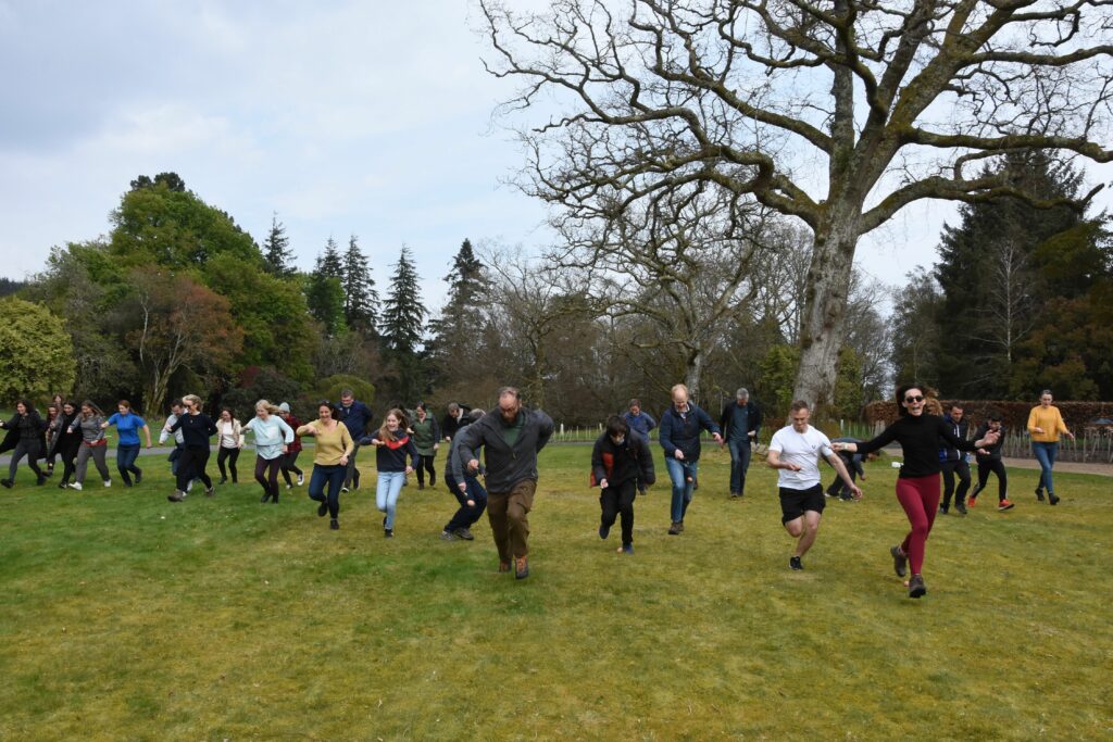 Adults race towards the finish line in the egg and spoon race.