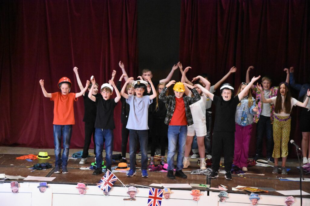 Pupils perform the Village People’s YMCA with some of the audience joining in.