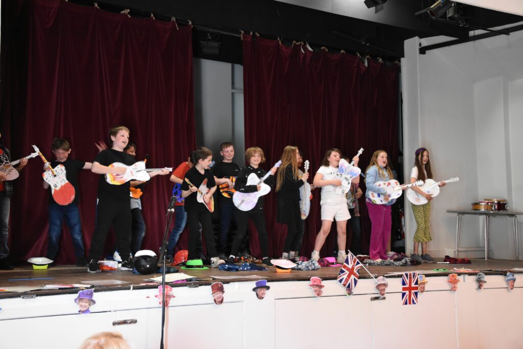 The concert becomes lively when the pupils pick up their paper guitars.