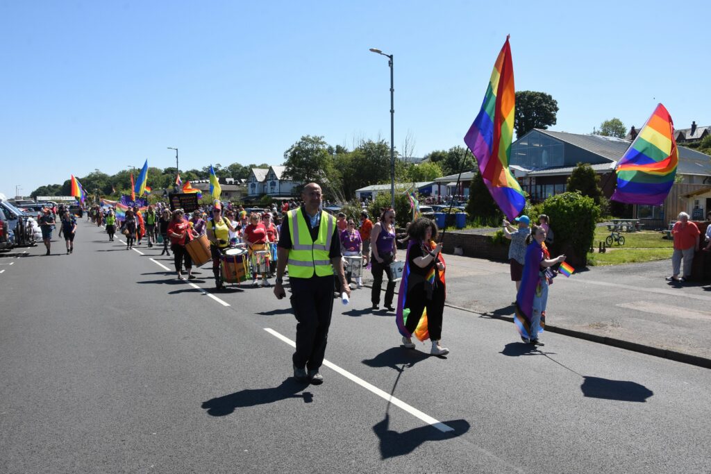 Adding a touch of colour to Brodick main road, the Pride march makes its way through the centre of the village.