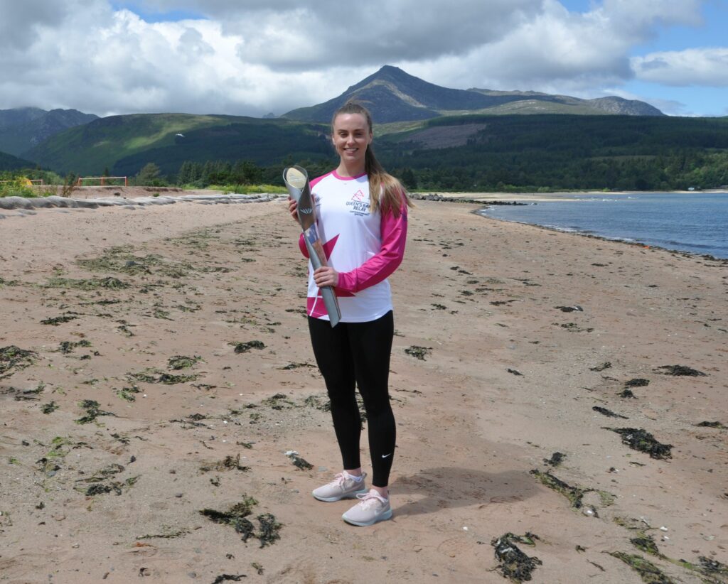 Eleanor O'Donnell with The Queen's Baton on Brodick beach.