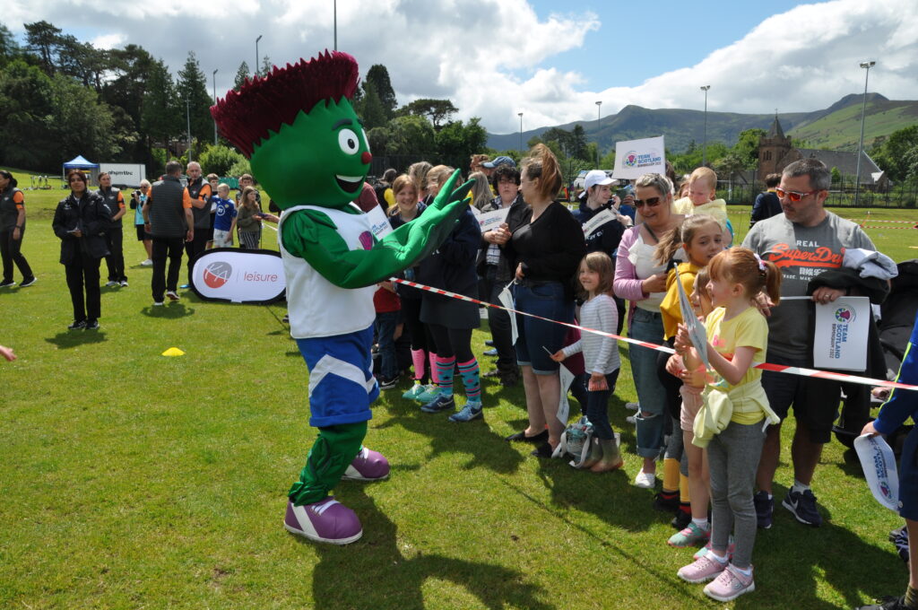 Clyde, the Team Scotland mascot, high fives some youngsters.