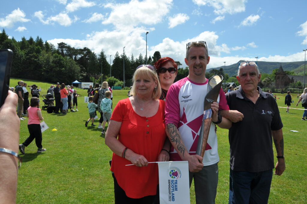Mark Nelson with mum and dad Dave and Marjorie and wife Helen and the baton.