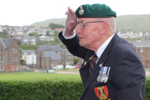 Falklands War veteran Bob Priest salutes after laying Campbeltown's commemorative wreath.