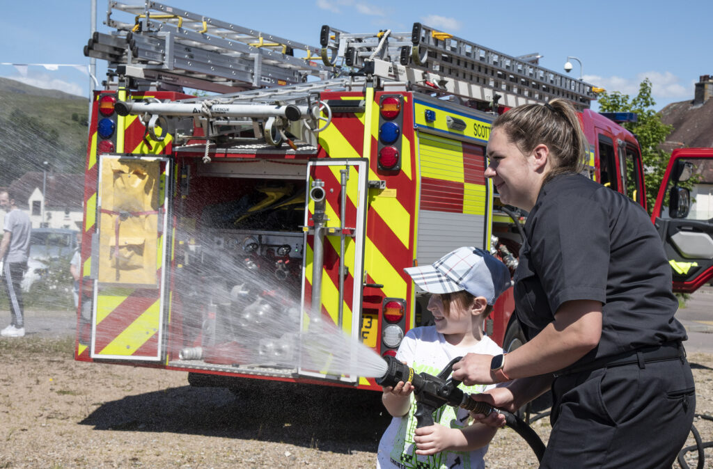 A cooling spray on a sunny day courtesy of the local Scottish Fire and Rescue Service . Photograph: Iain Ferguson, alba.photos

NO F23 Caol Community party 04