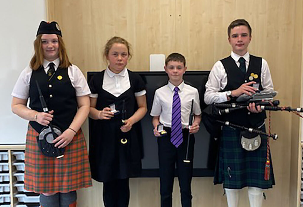 Chanter and novice winners, from left, are Lily Robertson, Libby Bezuidenhout, Jamie Smith and Alasdair MacKay. Photograph: Moira Robertson. 

NO F26 Mod chanters pipers MR