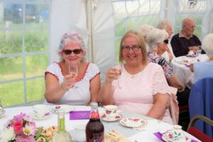 Barbara McEachran and Elizabeth McCrimmon raise a glass during Saturday afternoon's royal tea party.