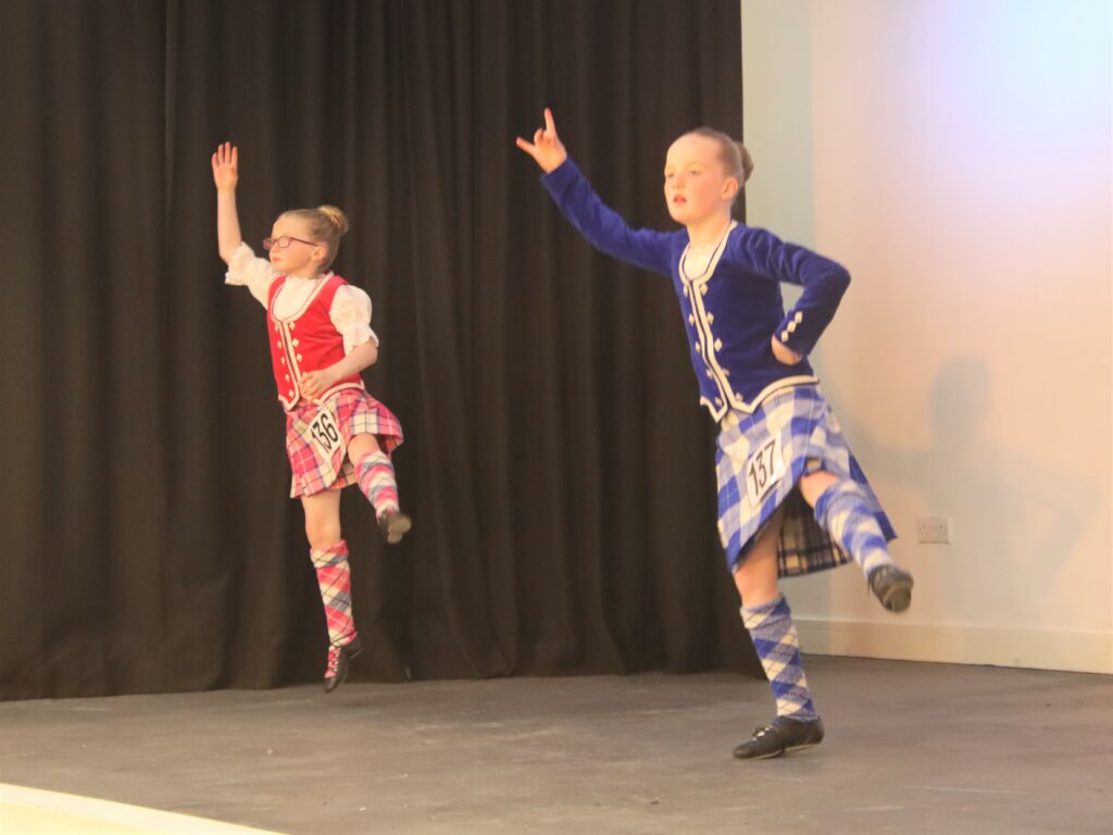 Highland dancers Christina McMillan and Maida Walker on stage.