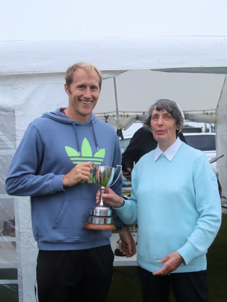 Jennifer McCorkindale presenting Drew Dutton, winner of the men’s Carskiey Cup and the Kevin Scally Mile Cup, with one of his trophies.