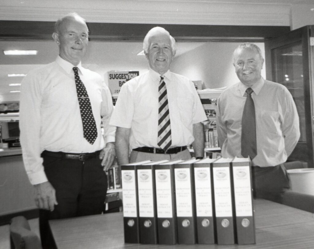 Stewart Lambie, chairman of Arran Antiquarians, and Norval Murray hand files containing their researched history of Arran between 1857 to 1928 from the files of the Ardrossan and Saltcoats Herald to Arran's retiring librarian Euan McConnell. 01_B30years06