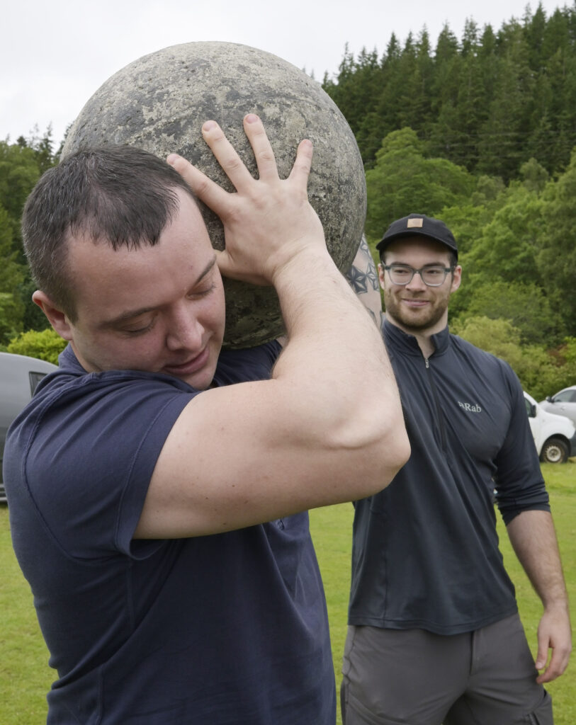 Making his first attempt at a strongman event,  Mikhail Mudrak gets some advice on lifting the Atlas Stones from Tom Baillie of Fort William's Iron Therapy Gym. Photograph: Iain Ferguson, alba.photos.