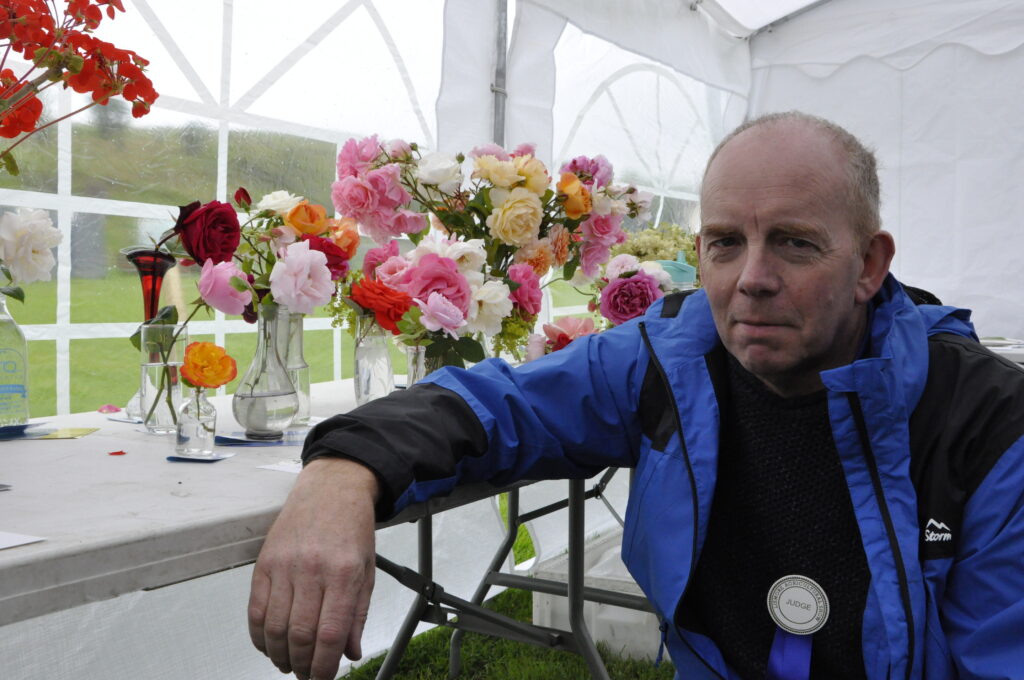 Horticulture judge Alan Campbell amid the floral displays.