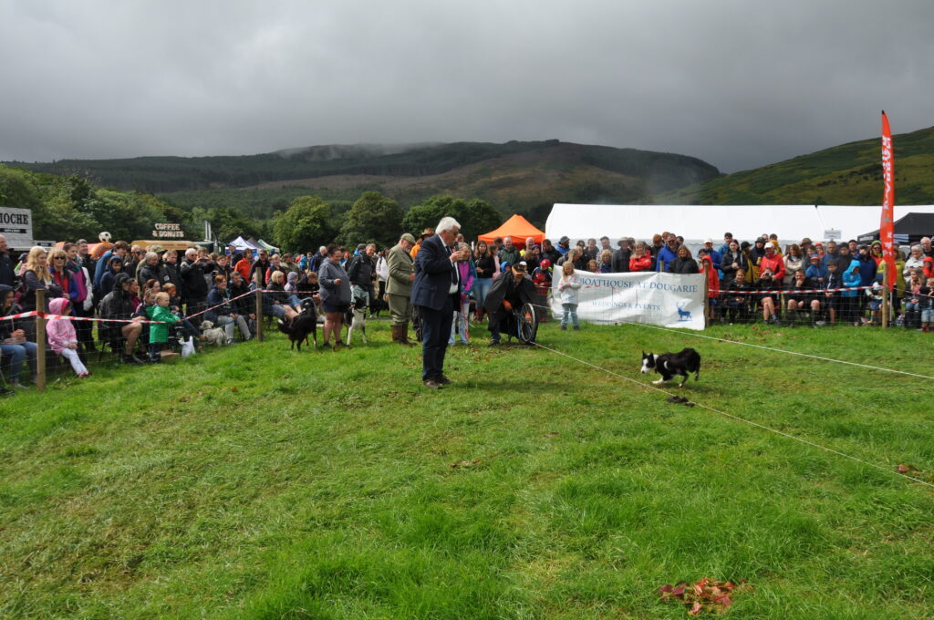 A big crowd watches the ever popular Murray's Dog Scurry as Charles Currie commentates on the fun.