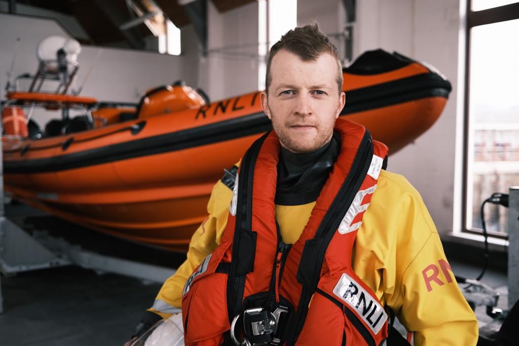 Kyle RNLI crew member Daniel in front of the station's lifeboat. Photograph: Andy Tobin. NO F18 Daniel in front of the lifeboat