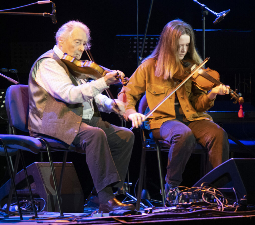 Famous fiddler Aonghas Grant on stage with pupil Thea Robertson who was playing to a large audience for the first time. Photograph: Iain Ferguson, alba.photos NO F20 Ukraine concert 02