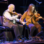 Famous fiddler Aonghas Grant on stage with pupil Thea Robertson who was playing to a large audience for the first time. Photograph: Iain Ferguson, alba.photos NO F20 Ukraine concert 02
