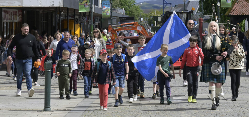 Children from the Gaelic were joined by a piper on the last leg of their sponsored walk from Caol to Fort William. Photograph: Iain Ferguson, alba.photos NO F22 Gaelic School sponsored walk 02