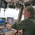Andy Jackson at the helm of the electric-powered wildlife cruise boat, Laurenca II. Photograph: Nic Goddard. NO F33 Andy Jackson edit