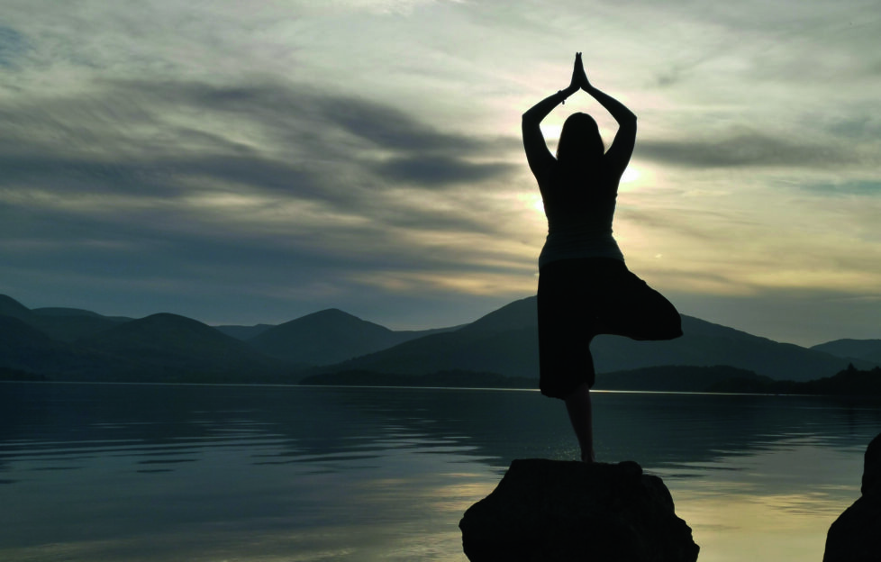 Wellness Events in Scotland 2024. Image: woman balancing on a rock in a yoga pose.