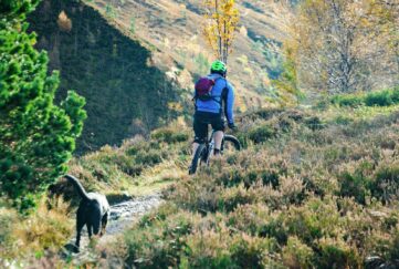 man cycling through hills in Scotland. 7 Autumn cycle routes in Scotland.