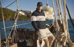 man wearing apparel from Rodd and Gunn UK poses on a boat while sailing