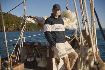 man wearing apparel from Rodd and Gunn UK poses on a boat while sailing