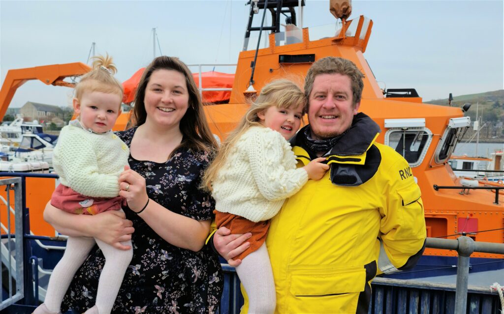 Campbeltown RNLI’s new full-time lifeboat coxswain Ruaridh McAulay with her partner Clare Lamont and their two daughters. Photograph: RNLI/Carla Jackson.
